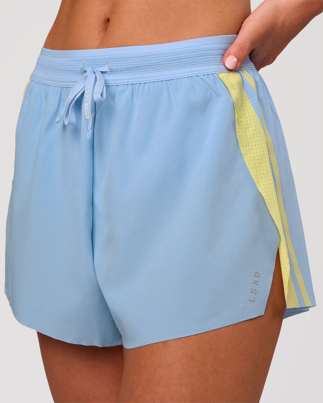 Woman wearing Accelerate 3" Force High-Rise Running Short - Open Air-Lemon | Model:Issy | Size:XS - view 1