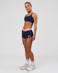 Woman wearing Accelerate 3" Mid-Rise Running Short - Future Navy-Varsity Print | Model:Issy | Size:XS | Thumbnail Index: 4