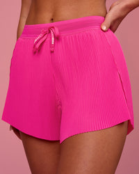 Woman wearing Accelerate 3" Pleated High-Rise Running Short - Ultra Pink | Model:Issy | Size:XS | Thumbnail Index: 0