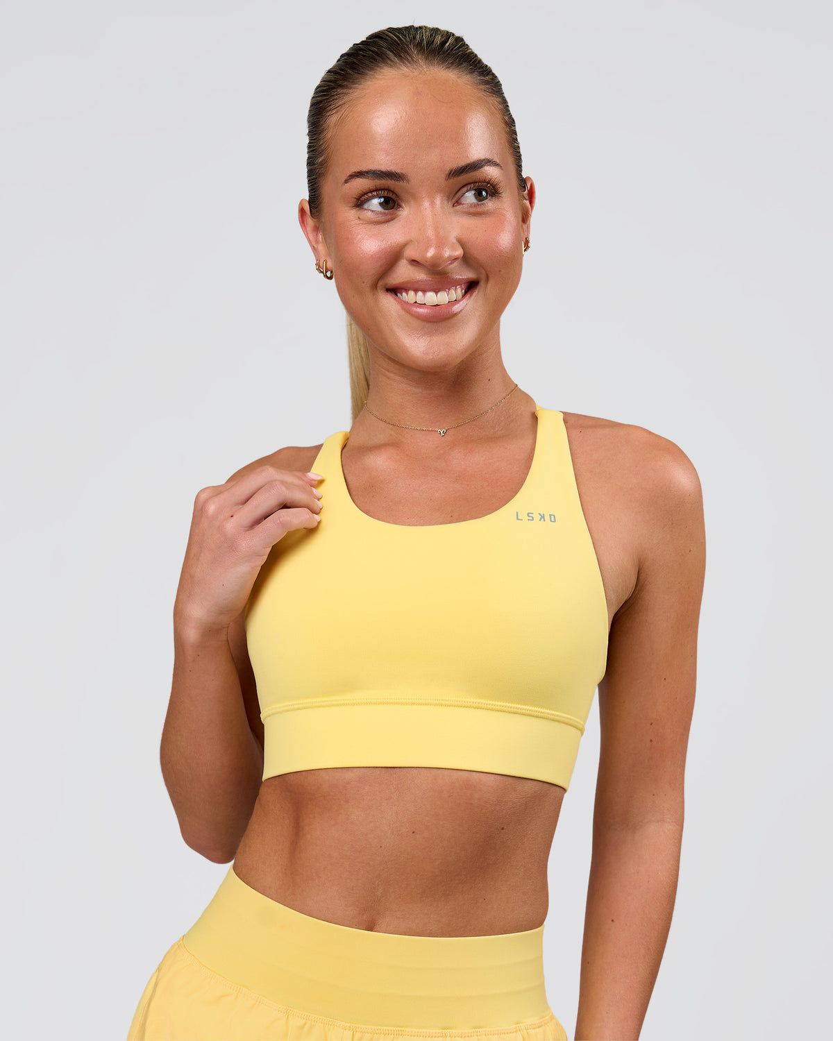 Woman wearing Accelerate Sports Bra - Lemon | Model:Issy | Size:XS
