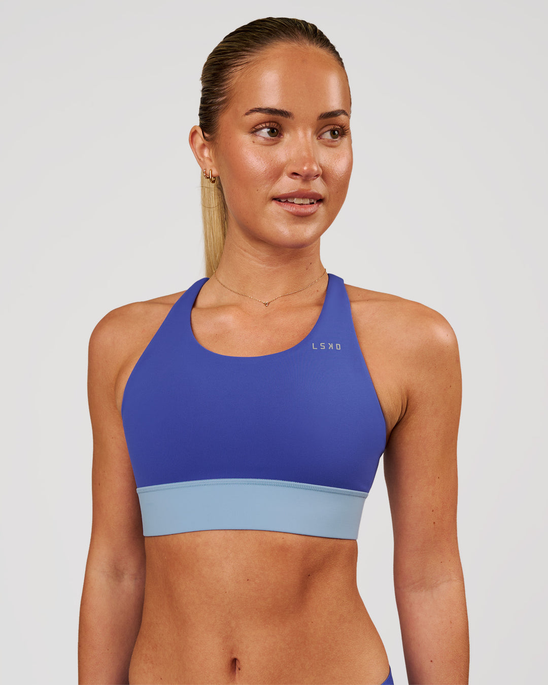 Woman wearing Accelerate Sports Bra - Power Cobalt-Open Air | Model:Issy | Size:XS - view 1