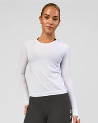 Woman wearing AeroFLX+ Seamless Long Sleeve Tee - White/White | Model:Issy | Size:XS | Thumbnail Index: 0