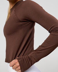 Woman wearing AeroFLX+ Long Sleeve Skimmer Half Zip - Hot Chocolate/Hot Chocolate | Model:Issy | Size:XS | Thumbnail Index: 1