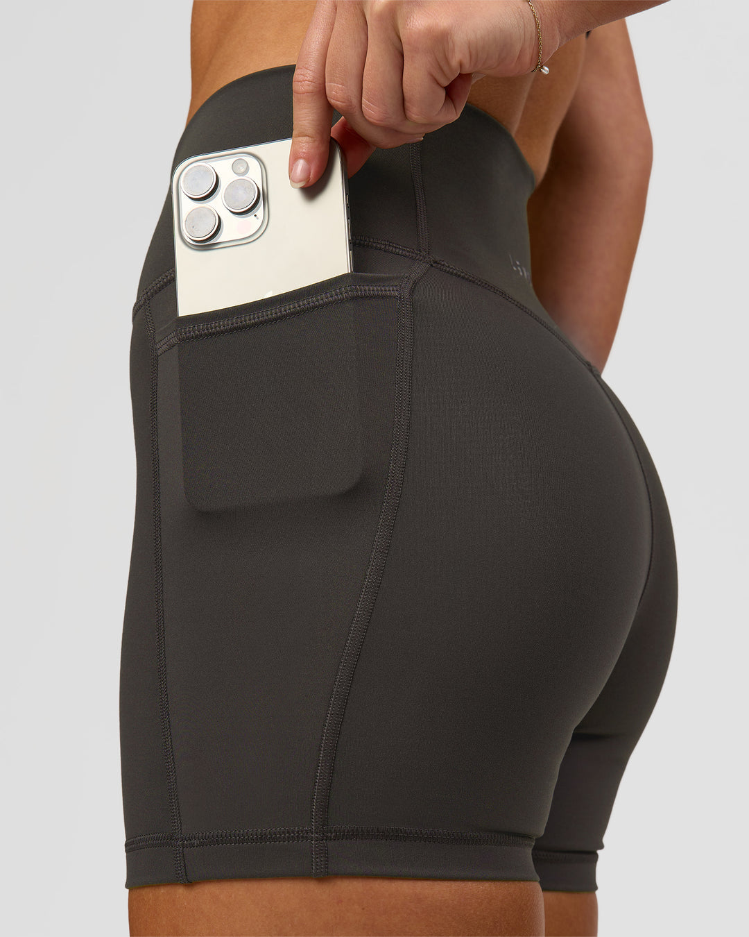 Woman wearing Fusion Ultra High-Rise 4" Short Pockets - Onyx | Model:Issy | Size:XS - view 6