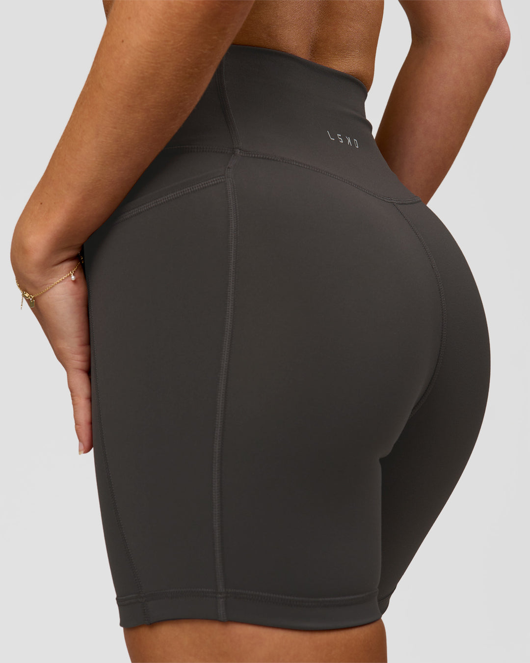 Woman wearing Fusion Ultra High-Rise 6" Short Pockets - Onyx | Model:Issy | Size:XS - view 2