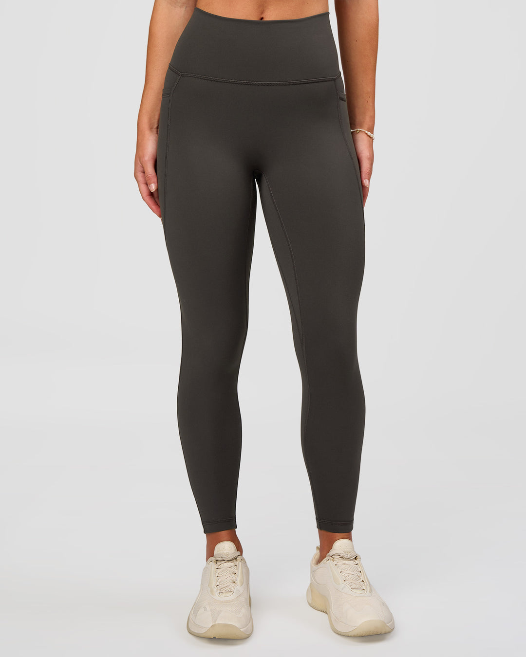 Woman wearing Fusion Ultra High-Rise 7/8 Legging Pockets - Onyx | Model:Issy | Size:XS - view 1