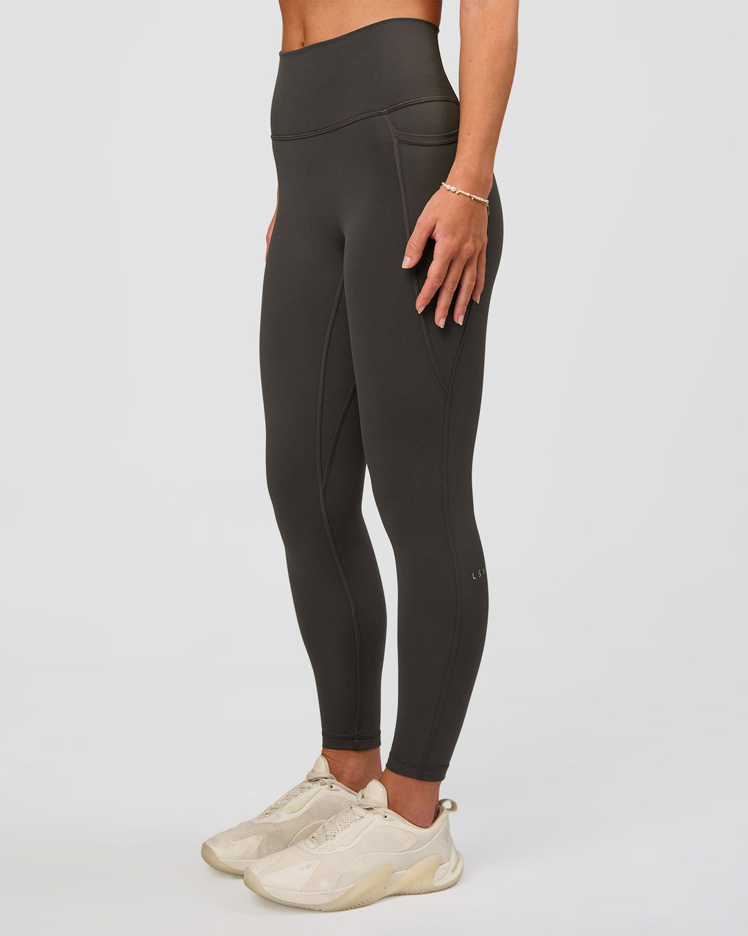 Woman wearing Fusion Ultra High-Rise 7/8 Legging Pockets - Onyx | Model:Issy | Size:XS - view 7