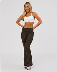 Woman wearing Fusion V-Contour High-Rise Flared Petite Legging Pockets - Ground Coffee | Model:Issy | Size:XS | Thumbnail Index: 7