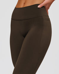 Woman wearing Fusion V-Contour High-Rise Flared Petite Legging Pockets - Ground Coffee | Model:Issy | Size:XS | Thumbnail Index: 8
