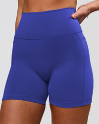 Woman wearing Fusion V-Contour Ultra High-Rise 4" Short Pockets - Power Cobalt | Model:Issy | Size:XS | Thumbnail Index: 0