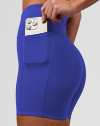 Woman wearing Fusion V-Contour Ultra High-Rise 4" Short Pockets - Power Cobalt | Model:Issy | Size:XS | Thumbnail Index: 1