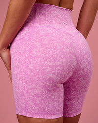 Woman wearing Fusion V-Contour Ultra High-Rise 6" Short Pockets - Energy Print Marshmallow | Model:Issy | Size:XS | Thumbnail Index: 0