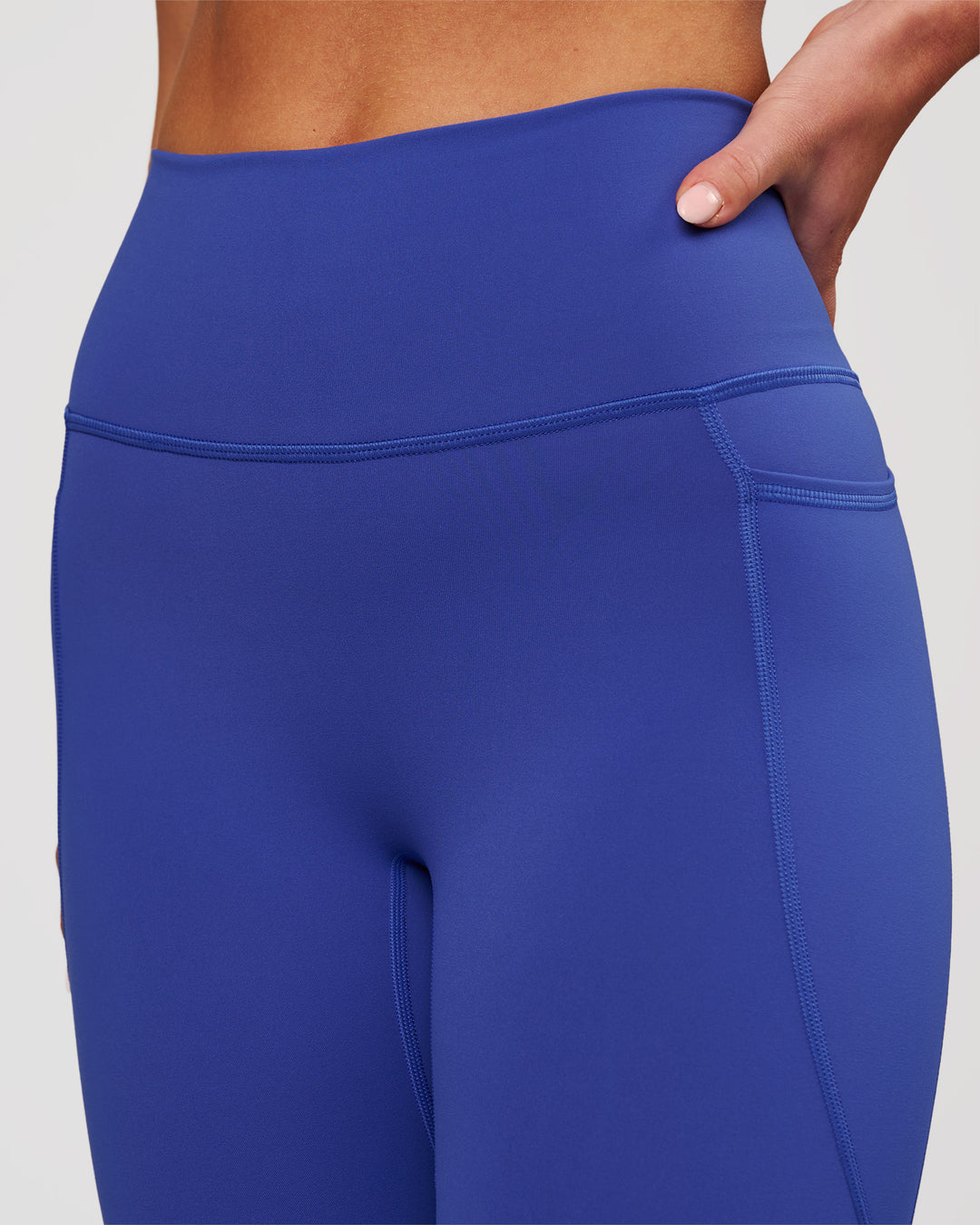 Woman wearing Fusion V-Contour Ultra High-Rise 7/8 Legging Pockets - Power Cobalt | Model:Issy | Size:XS - view 3