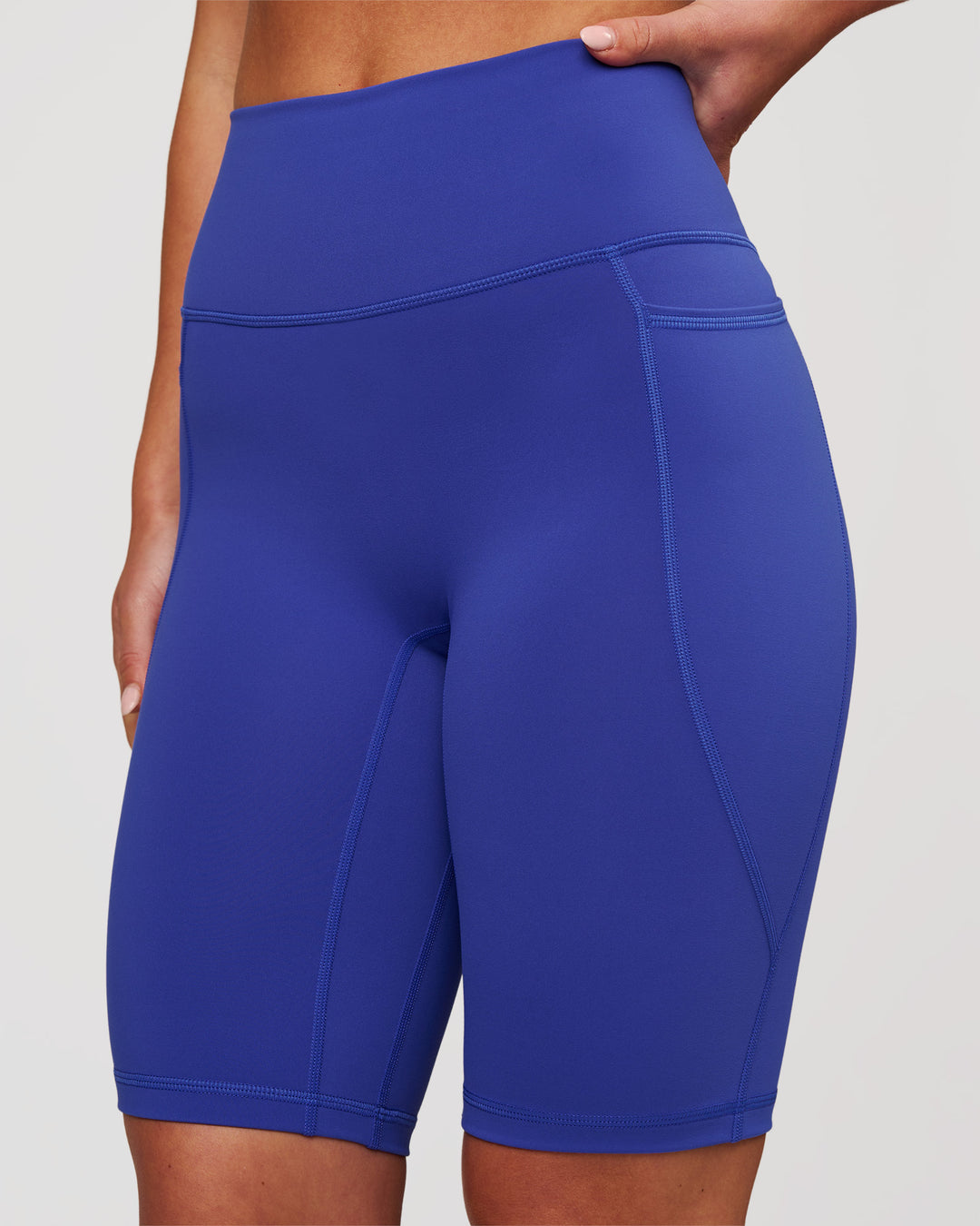 Woman wearing Fusion V Contour Ultra High-Rise 9" Short Pockets - Power Cobalt | Model:Issy | Size:XS - view 2