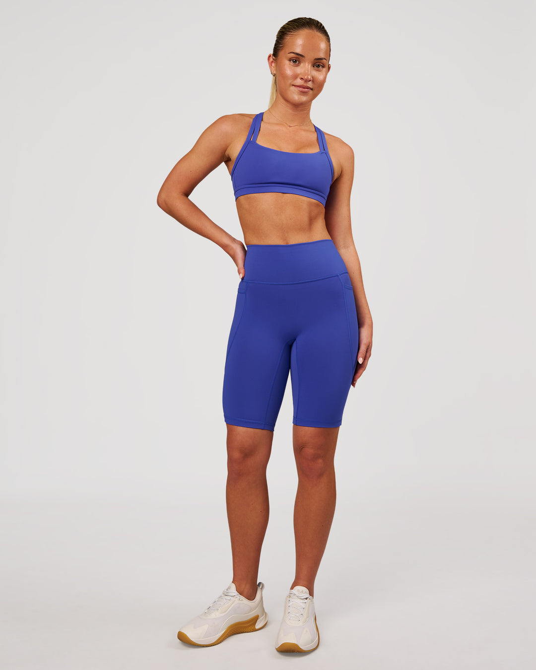 Woman wearing Fusion V Contour Ultra High-Rise 9" Short Pockets - Power Cobalt | Model:Issy | Size:XS - view 5
