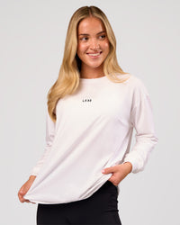 Woman wearing Go-To Long Sleeve FLXCotton Oversized Tee - White-Black | Model:Issy | Size:XS | Thumbnail Index: 0