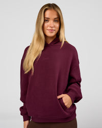 Woman wearing Go-To Oversized Hoodie - Cherry Lacquer | Model:Issy | Size:XS | Thumbnail Index: 0