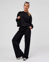 Woman wearing Go-To Oversized Sweater - Black | Model:Issy | Size:XS
