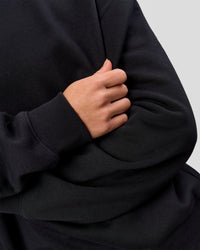 Woman wearing Go-To Oversized Sweater - Black | Model:Issy | Size:XS
