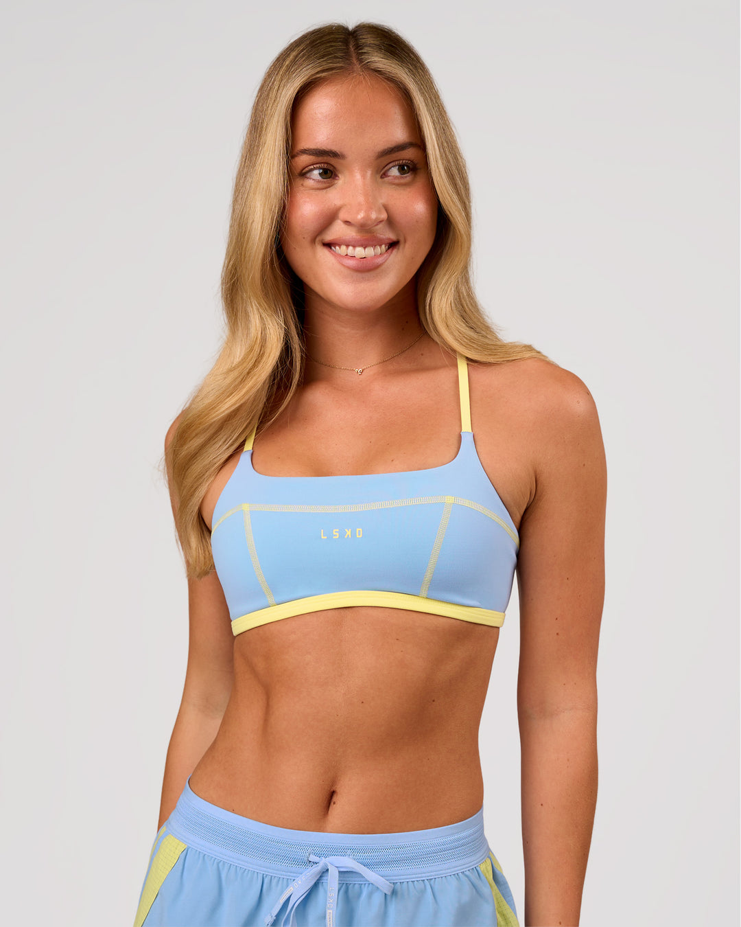 Woman wearing Liberate Sports Bra - Open Air-Lemon | Model:Issy | Size:XS - view 4