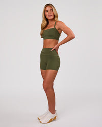 Woman wearing Momentum Corset Sports Bra - Pure Olive | Model:Issy | Size:XS | Thumbnail Index: 3