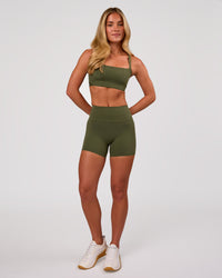 Woman wearing Momentum Corset Sports Bra - Pure Olive | Model:Issy | Size:XS | Thumbnail Index: 4
