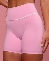Woman wearing Pinnacle High-Rise 6" Short - Pink Rose-White | Model:Issy | Size:XS | Thumbnail Index: 1