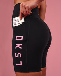 Woman wearing Rep Ultra High-Rise 6" Short Pockets - Black-Pink Rose | Model:Issy | Size:XS | Thumbnail Index: 0
