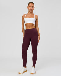Woman wearing Rep Ultra High-Rise 7/8 Legging Pockets - Cherry Lacquer-White | Model:Issy | Size:XS | Thumbnail Index: 0