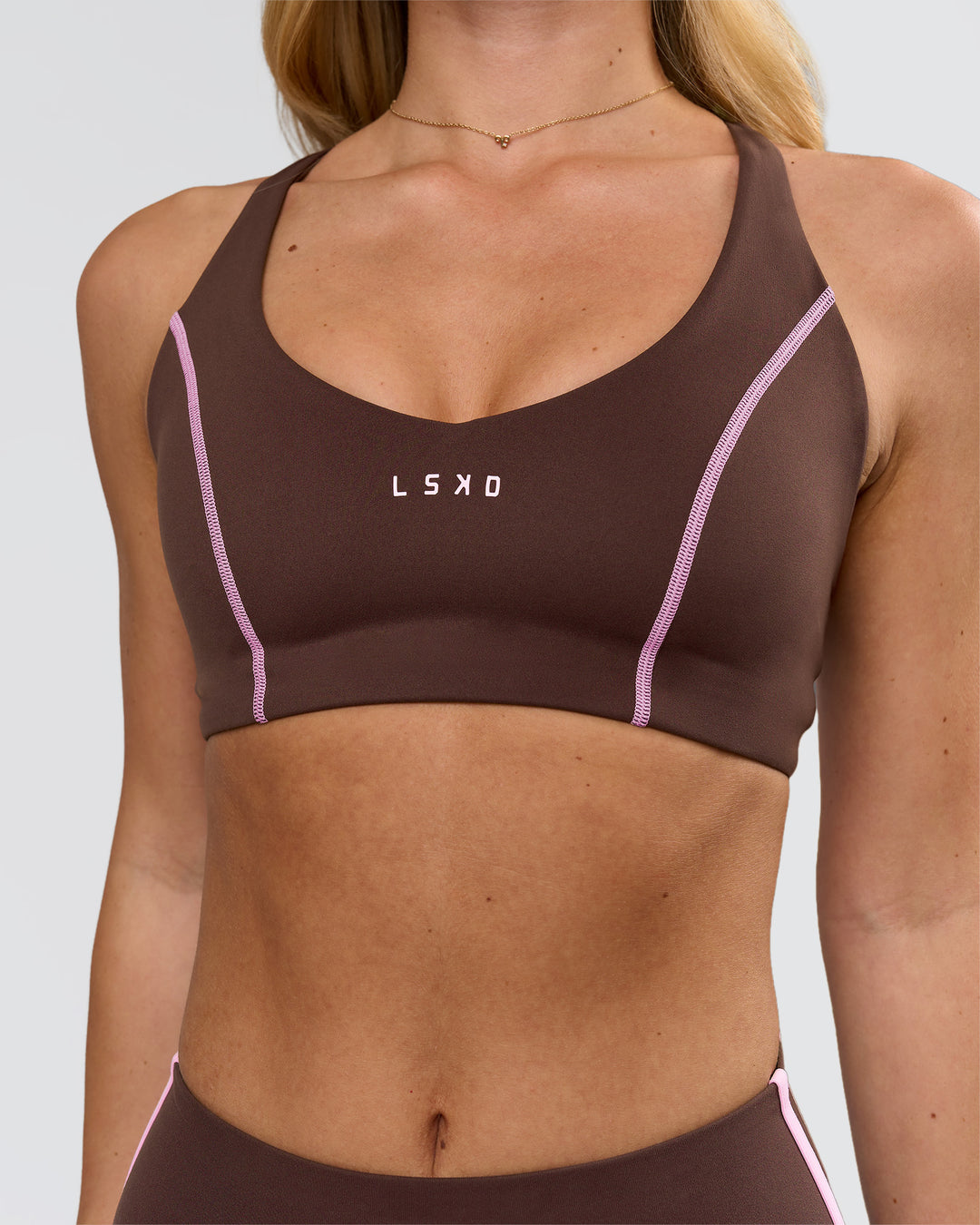 Woman wearing Stellar Sports Bra - Hot Chocolate-Pink Rose | Model:Issy | Size:XS - view 2