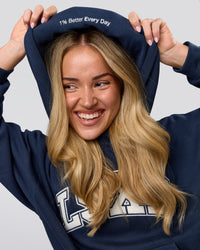 Woman wearing Varsity Boxy Hoodie - Future Navy-White | Model:Issy | Size:XS | Thumbnail Index: 16