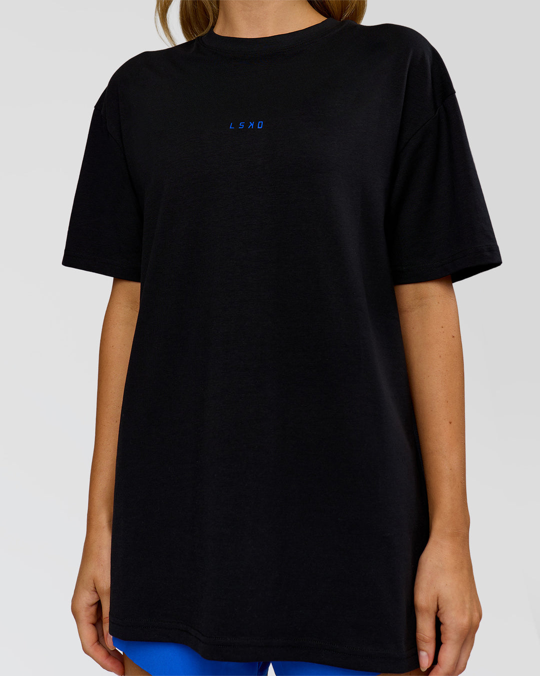 Woman wearing Run Club Elevate FLXCotton Oversized Tee - Black-Electric Indigo | Model:Leilani | Size:XS