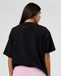Woman wearing League Heavyweight FLXCotton Oversized Tee - Black-Power Cobalt | Model:Rhiley | Size:XS