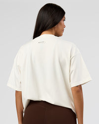 Woman wearing League Heavyweight FLXCotton Oversized Tee - Off White-Ground Coffee | Model:Rhiley | Size:XS