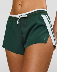 Woman wearing Trackline Accelerate 3" Mid Rise Running Short - Midnight Green-White | Model:Taneisha | Size:XS | Thumbnail Index: 0