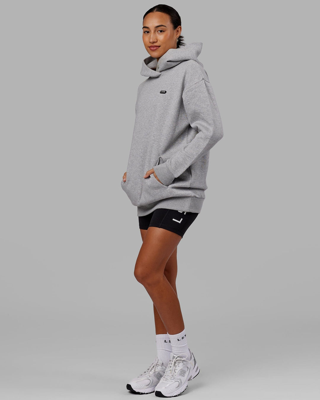 Woman wearing Unisex Capsule Hoodie Oversize - Lt Grey Marl