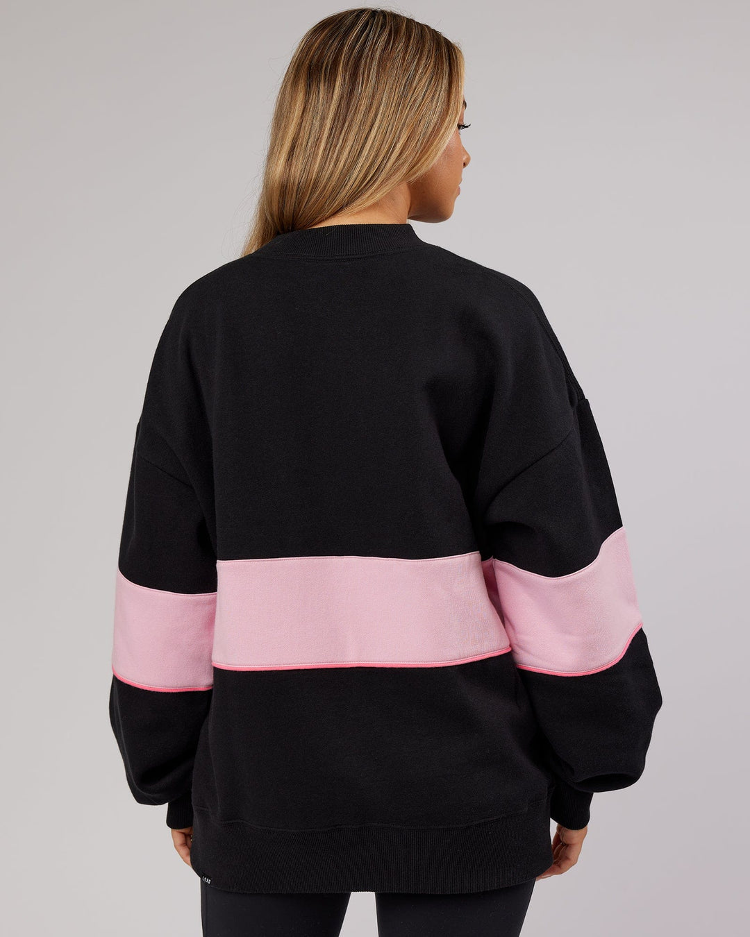 Woman wearing Unisex Extra Time Sweater Oversize - Black-Petal Pink