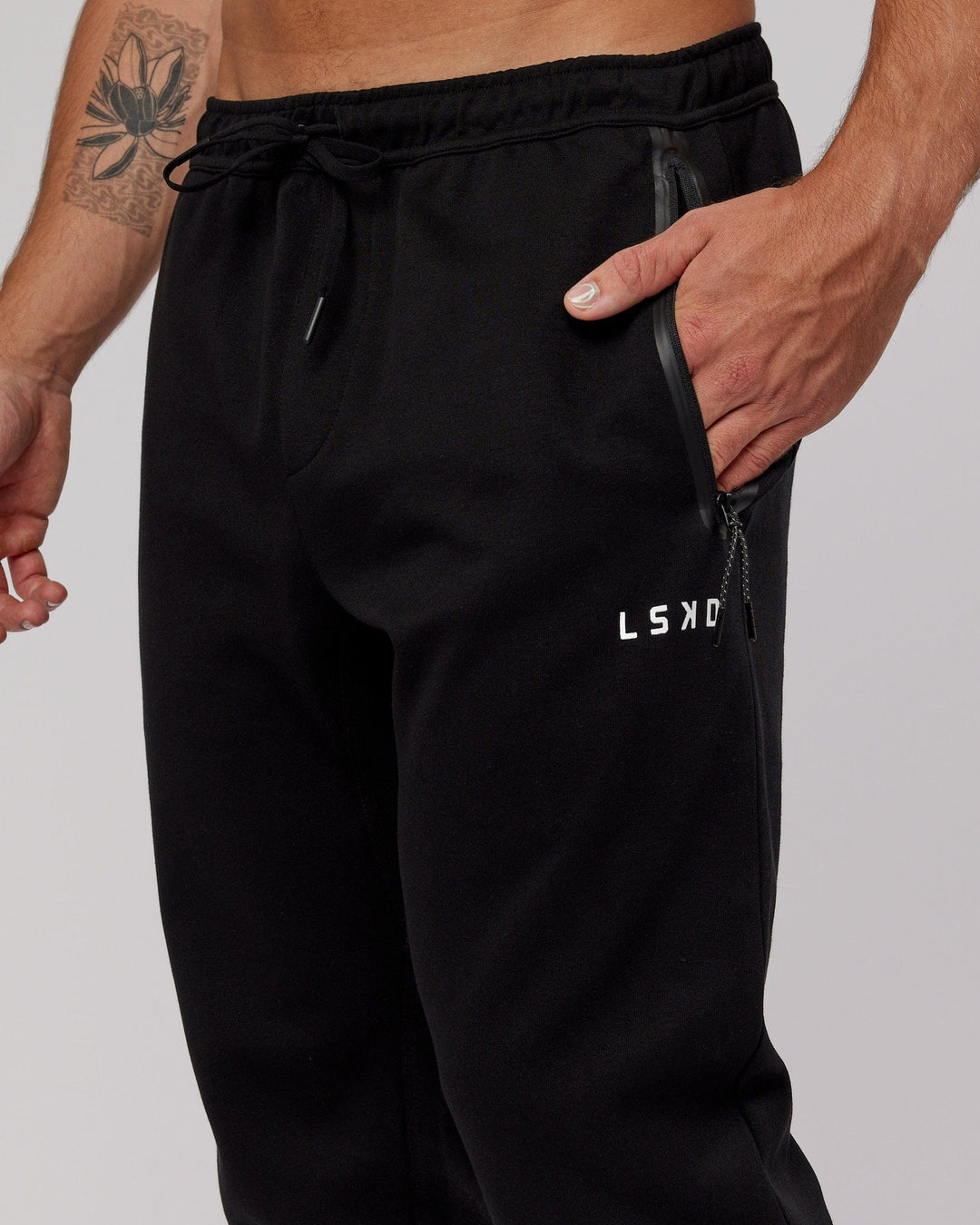 Man wearing Athlete ForgedFleece Zip Trackpant - Black