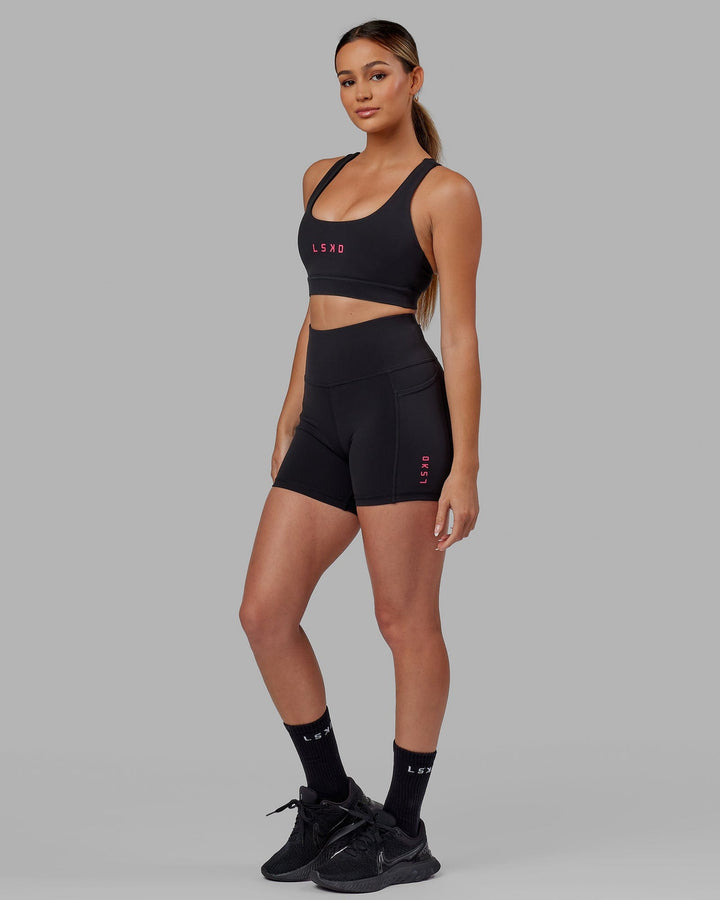 Woman wearing Rep Sports Bra Small Logo - Black-Boysenberry