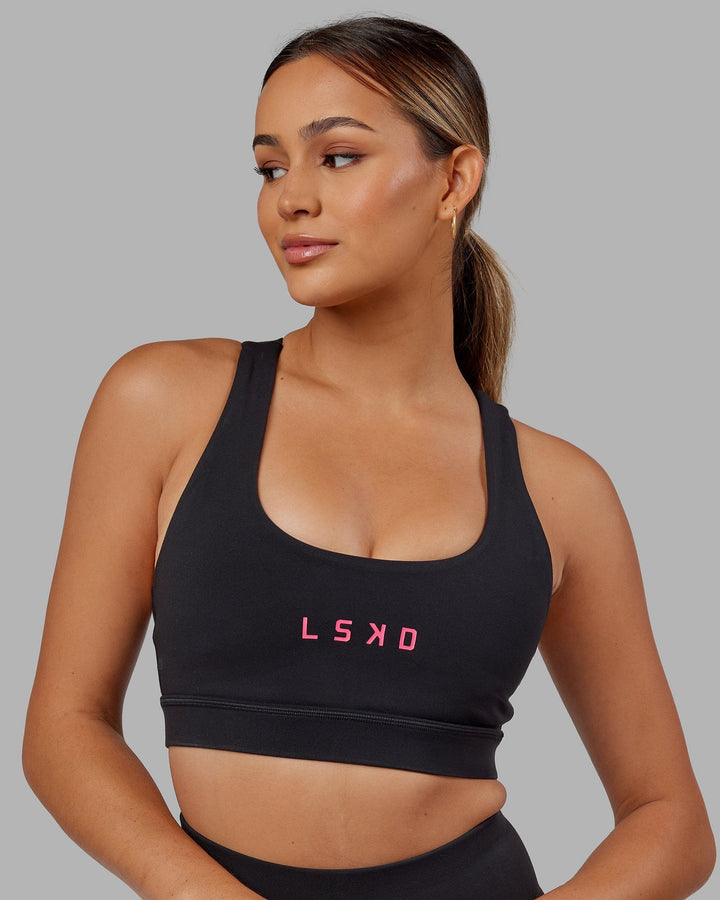 Woman wearing Rep Sports Bra Small Logo - Black-Boysenberry