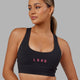 Woman wearing Rep Sports Bra Small Logo - Black-Boysenberry