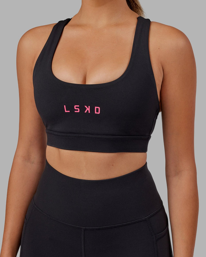 Woman wearing Rep Sports Bra Small Logo - Black-Boysenberry