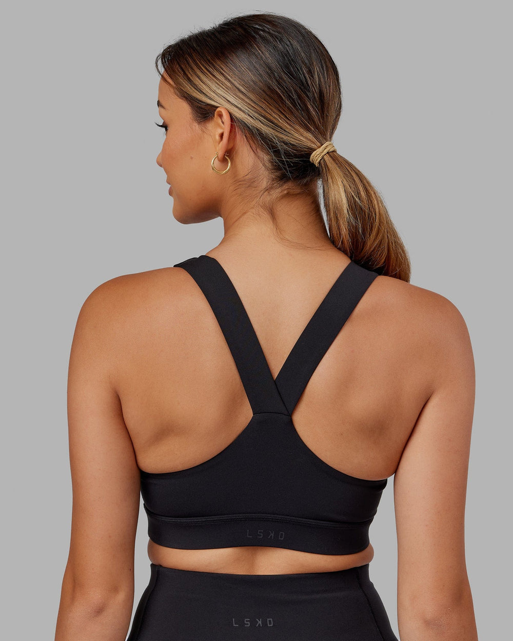 Woman wearing Rep Sports Bra Small Logo - Black-Boysenberry