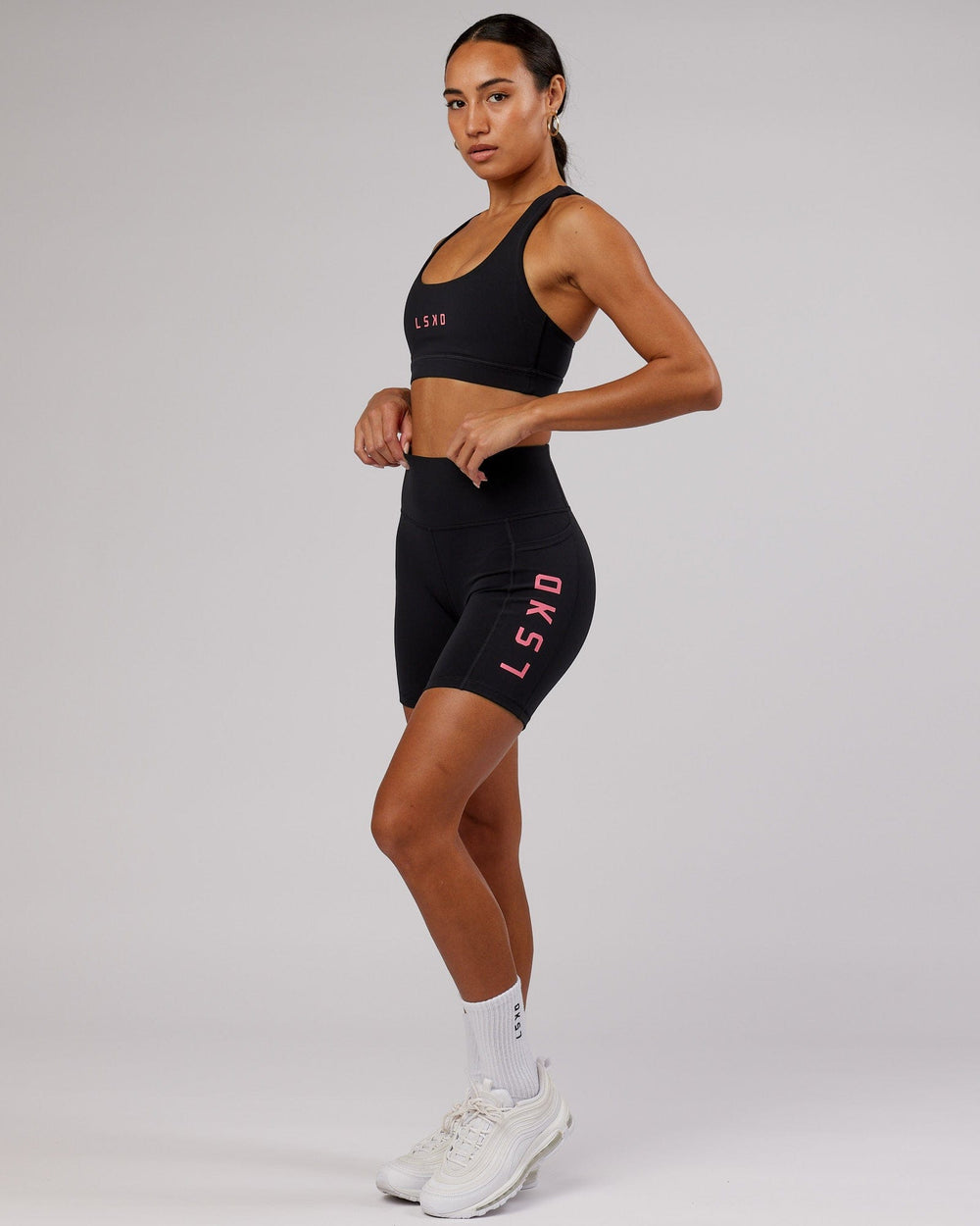 Woman wearing Rep Sports Bra Small Logo - Black-Flamingo