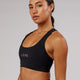 Woman wearing Rep Sports Bra Small Logo - Black-Flamingo