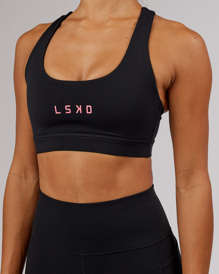 Woman wearing Rep Sports Bra Small Logo - Black-Flamingo