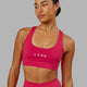 Woman wearing Rep Sports Bra Small Logo - Boysenberry