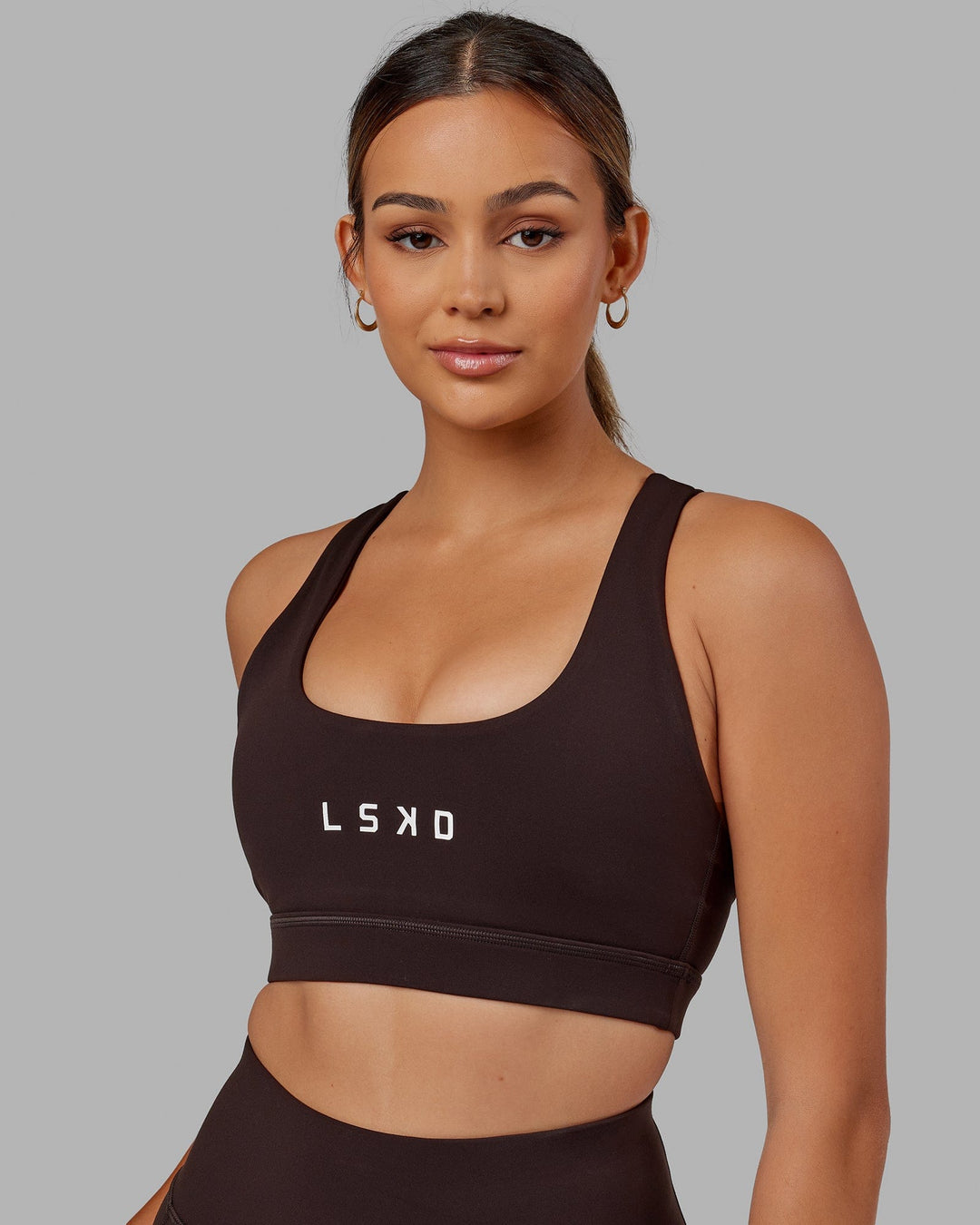 Woman wearing Rep Sports Bra Small Logo - Dark Walnut