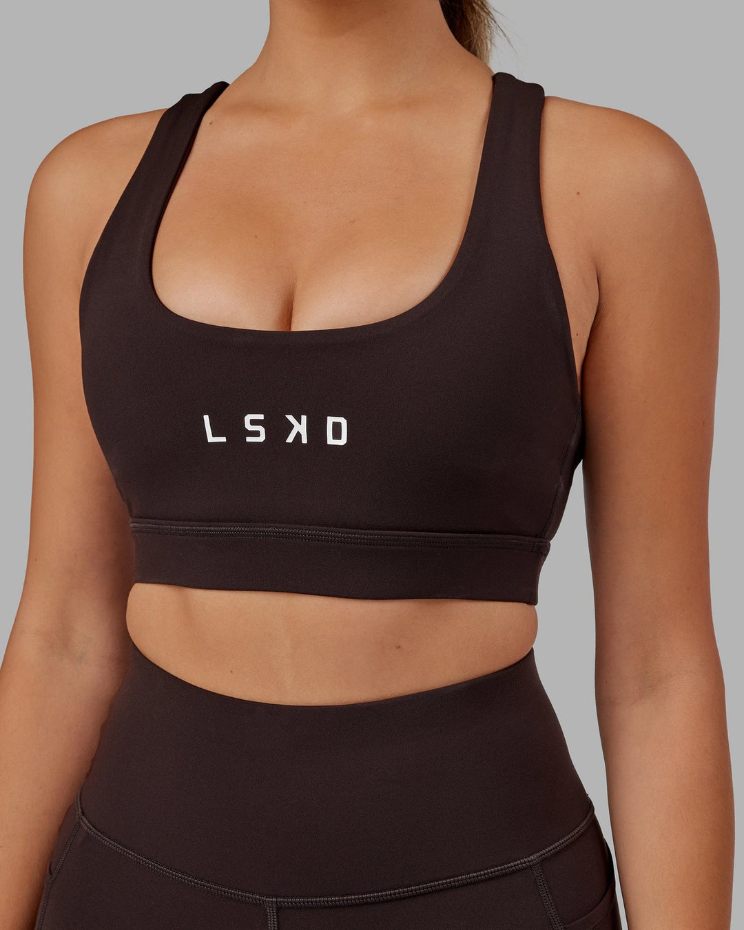 Woman wearing Rep Sports Bra Small Logo - Dark Walnut