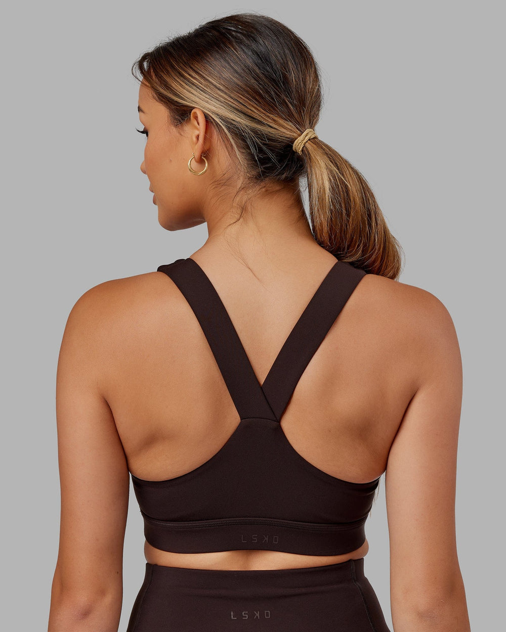 Woman wearing Rep Sports Bra Small Logo - Dark Walnut